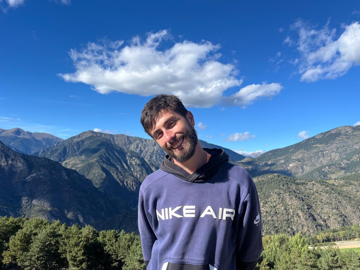 Alex, close portrait, natural light, mountains behind him
