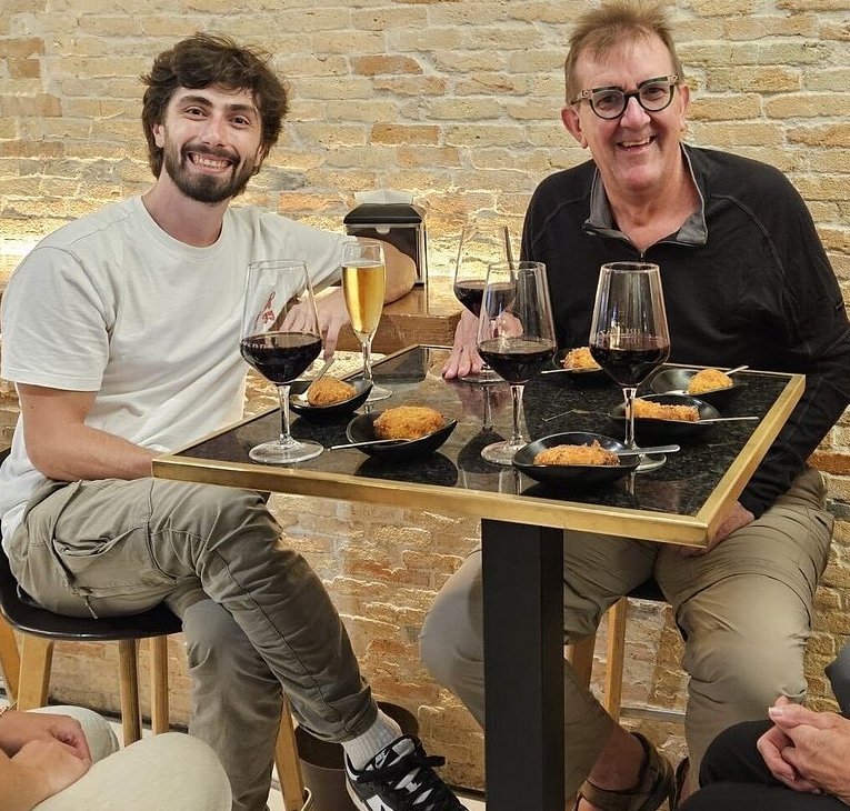 Alex raising a toast with a client at a pintxo bar in San Sebastián