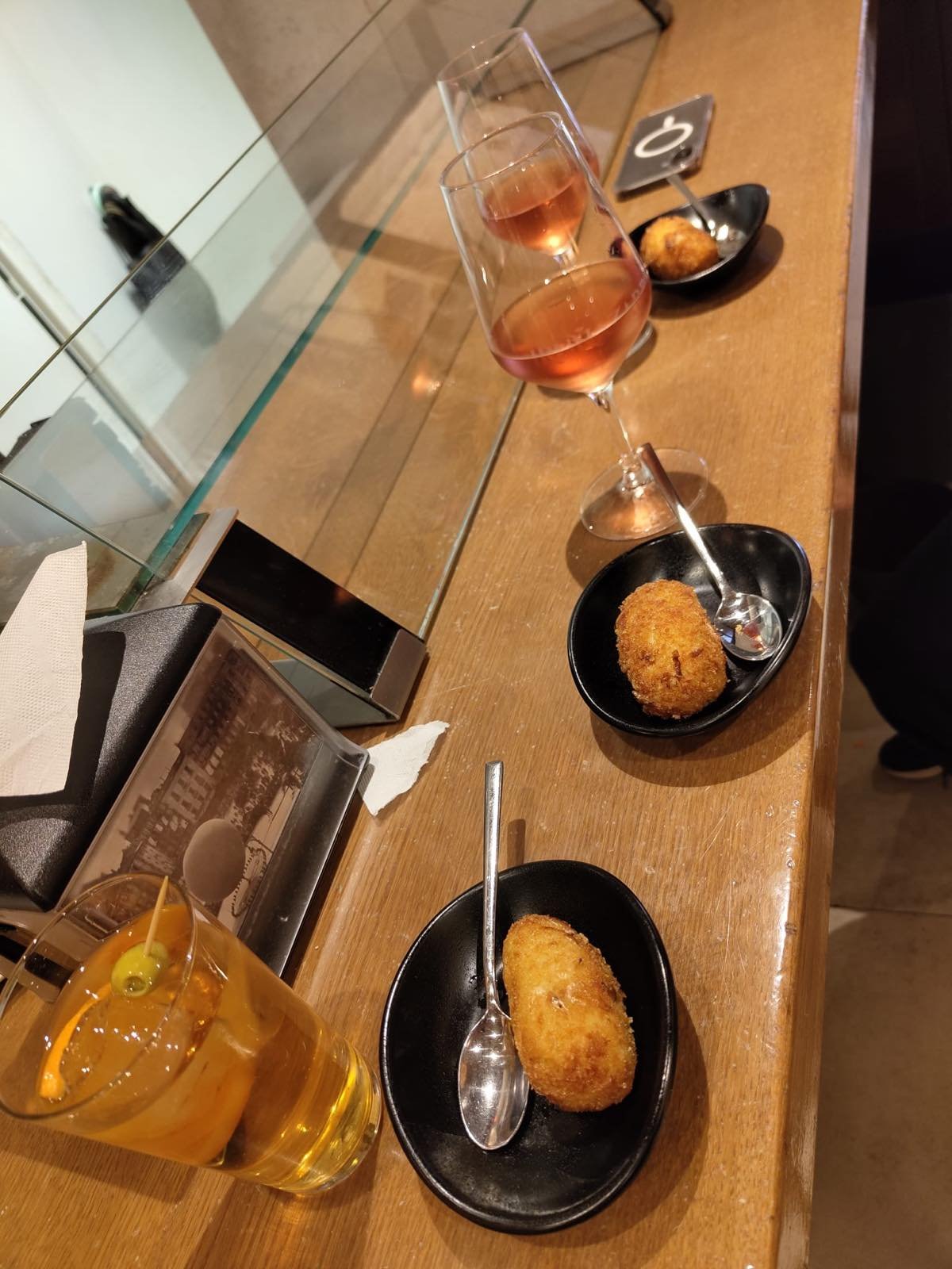 A croqueta pintxo and wine on a bar counter in Pamplona
