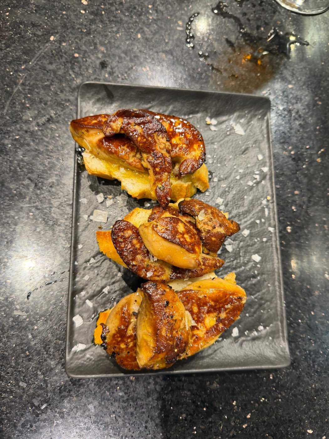 Close-up of grilled pintxos on a slate tray