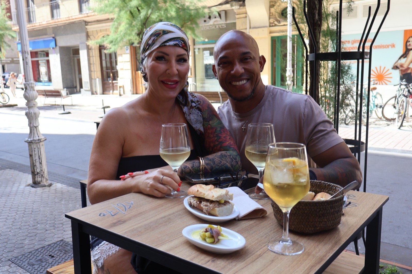 A couple at a seafront terrace in San Sebastián, drinks in hand