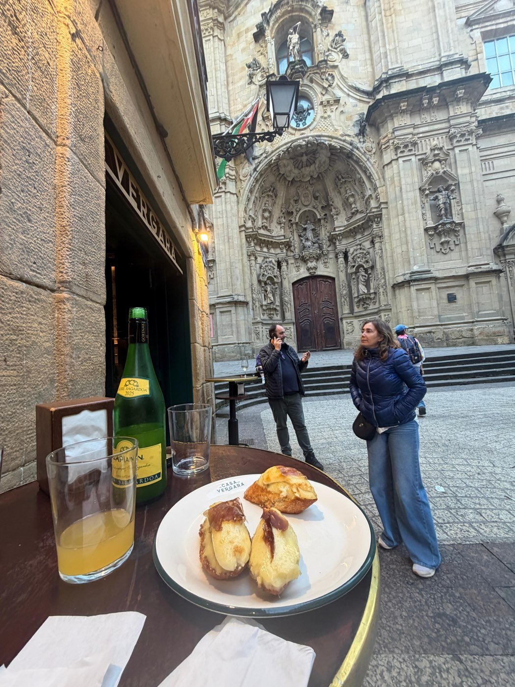 Bar terrace in Parte Vieja with cider and pintxos, Basílica de Santa María in the background